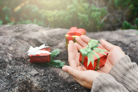 Female hands holding gift box on stone ,Christmas and New year conceptの写真素材
