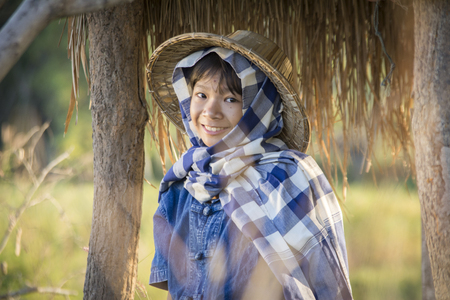 Asian farmer girl working at rice field on harvest season, selective and soft focusの写真素材