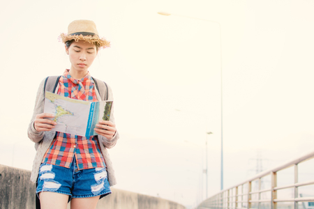 Asian women backpacker with map relax time on vacation hipster lifestyle, color style vintage toneの写真素材