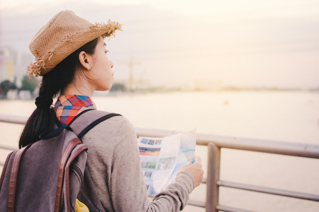Asian women backpacker with map relax time on vacation hipster lifestyle, color style vintage toneの写真素材