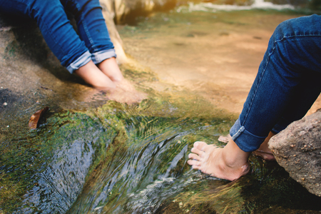 Feet of children in water on the forest, Relax time and vacation conceptの写真素材