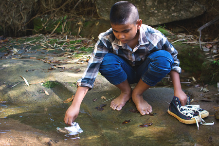Boy picking up plastic garbage in forest ,volunteer conceptの写真素材