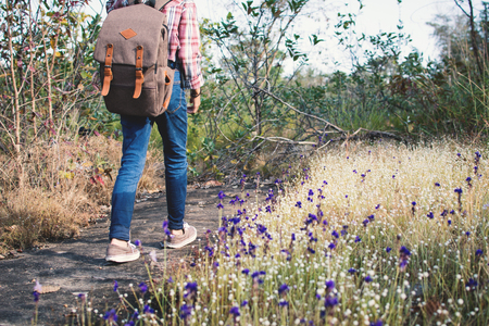 Feet of girl walking in beautiful flower filed background, Relax time on holidayの写真素材