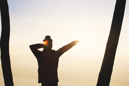 Silhouette of happy woman tourist waiting for sunset relax time and holiday, color vintage style selective and soft focusの写真素材