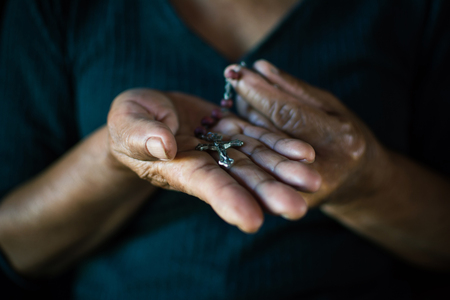 Close up of old hands praying on black background, Concept hope and worshipの写真素材