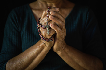 Close up of old hands praying on black background, Concept hope and worshipの写真素材
