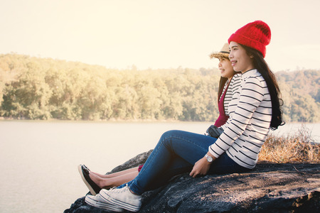 Asian women sitting on rock in nature , Relax time on holiday concept travel,selective and soft focus,tone of hipster styleの写真素材