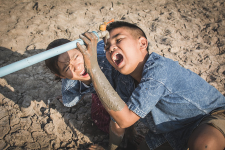 Sad children want to drink some water on crack ground , Concept drought and shortage of water crisis
