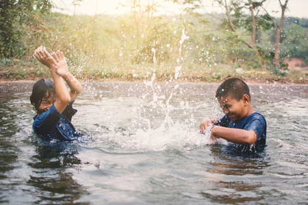 Happy moment Asian children playing water in outdoor , relax time and summer seasonの写真素材