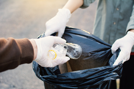 Human hand picking up empty of bottle plastic on park ,volunteer concept