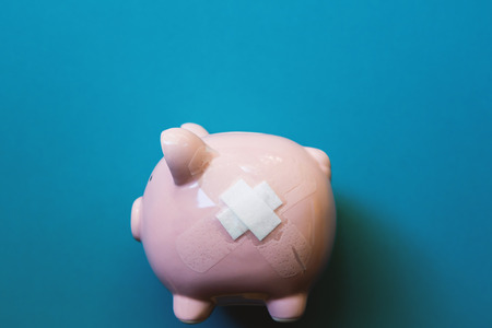 Piggy bank with money on blue background saving concept.の写真素材