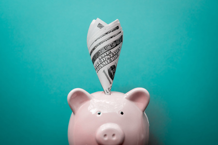 Piggy bank with money on blue background saving concept.の写真素材
