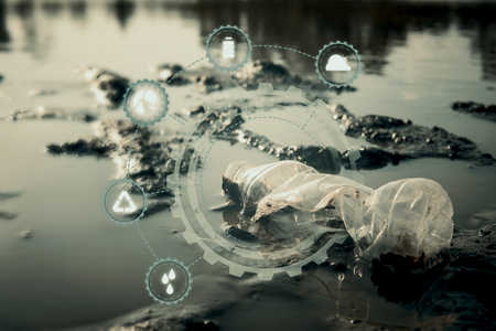 Close up bottle plastic with icon on crack ground beside the lake outdoor on the baking hot day, Drought and environmental problems.の写真素材