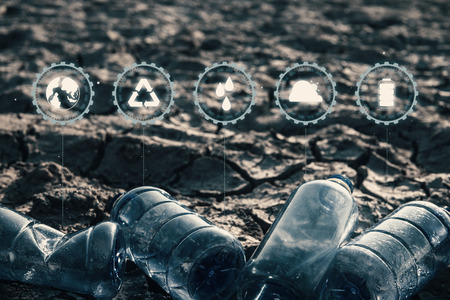 Close up bottle plastic with icon on crack ground beside the lake outdoor on the baking hot day,...