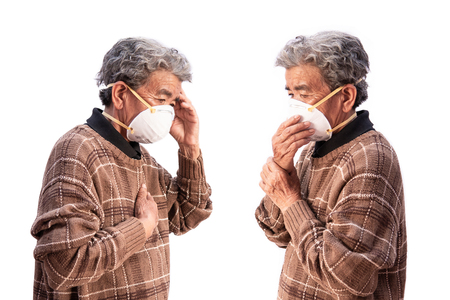 Old woman wearing a mask fear problem air pollution on a white background, healthcare concept.の写真素材