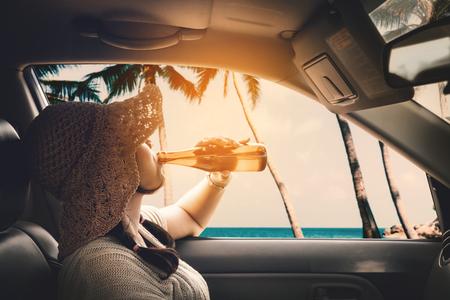 Happy woman sitting in the car and traveling summer season on the sea resting and special day to vacation.の写真素材
