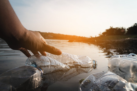 The volunteer picking up a bottle plastic in the river , protect environment from a pollution concept.の写真素材