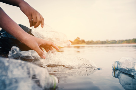 The volunteer picking up a bottle plastic in the river , protect environment from a pollution concept.の写真素材