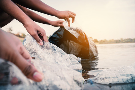 The volunteer picking up a bottle plastic in the river , protect environment from a pollution concept.の写真素材