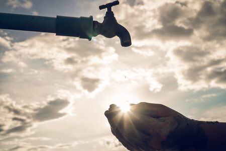 Silhouette of young hand waiting for water, Hope and drought crisis from the global warming concept.の写真素材