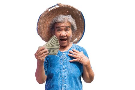 Happy old farmer woman holding a money on a white background.の写真素材