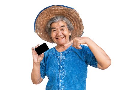 Happy old farmer woman holding a smart card on a white background.の写真素材