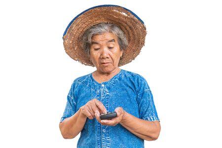Happy old farmer woman holding a calculator on a white background. Calculate income and expenses concept.の写真素材