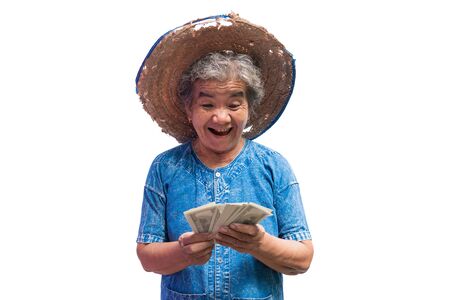 Happy old farmer woman holding a money on a white background.の写真素材