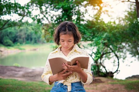 Asian girl reading a book during hobby time.の写真素材
