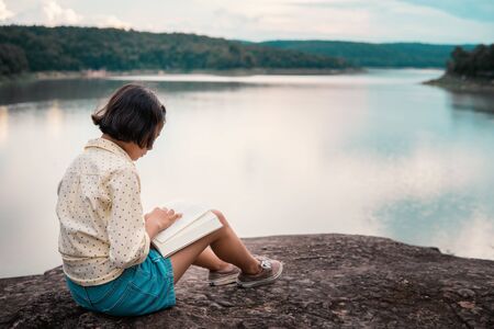 Asian girl reading a book during hobby time.の写真素材