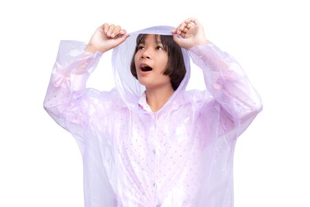Cute Asian girl in raincoat on the white background. The rainy season concept.の写真素材