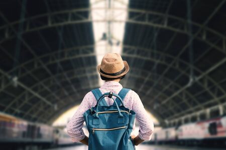 Asian girl backpacking starting traveling on train station, journey on holiday.の写真素材