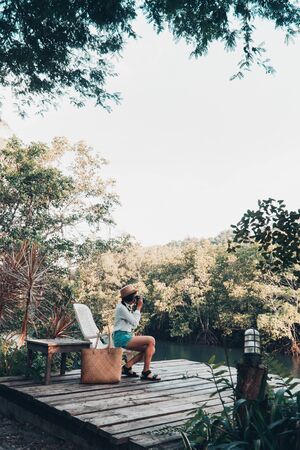 Cute girl enjoy with the nature resting and looking on the river.の写真素材