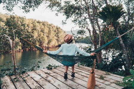 Cute girl enjoy with the nature resting and looking on the river and mangrove forest.の写真素材