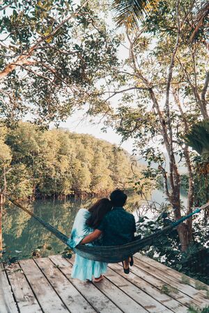 A couple enjoys the natural resting and looking on the river and mangrove forest.の写真素材
