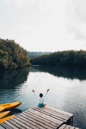 The cute girl enjoys the natural resting and looking on the river and mangrove view.の写真素材