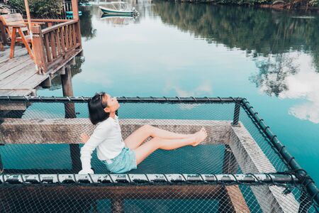 The cute girl enjoys the natural resting and looking on the river and mangrove view.の写真素材
