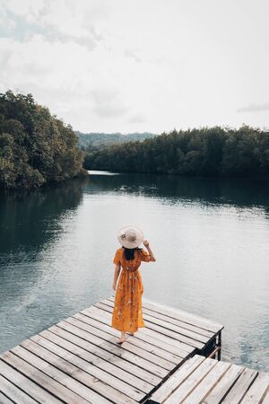 The cute girl enjoys the natural resting and looking on the river and mangrove view.の写真素材