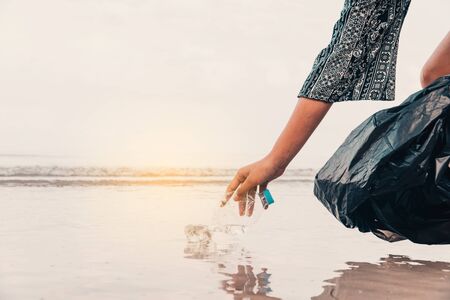 Hand picking up plastic bottle cleaning on the beach , volunteer concept.の写真素材