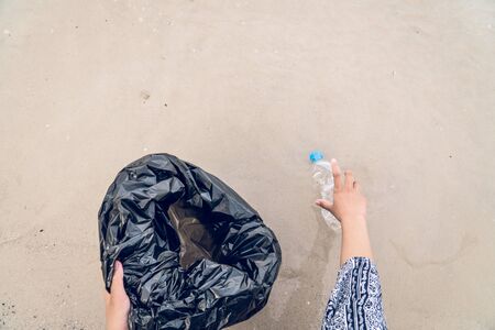 Hand picking up plastic bottle cleaning on the beach, volunteer concept.の写真素材