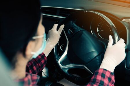Woman driving and wearing protective equipment from corona virus covid-19.の写真素材