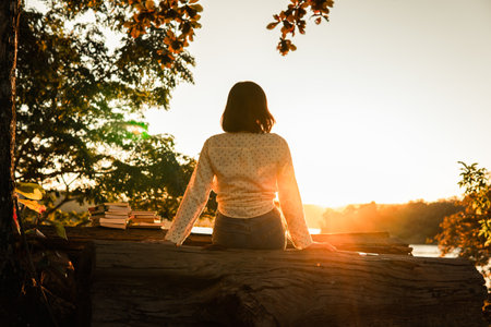 Asian female resting on the park during sunset, selective and soft focus.の写真素材