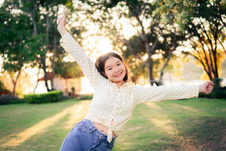 Happy teen younger open hand relaxing on the parkの写真素材