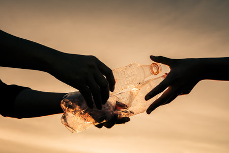 Silhouette human hand keeping plastic bottle and garbage in the natureの写真素材
