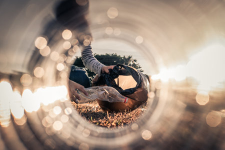 Human hand keeping plastic bottle and garbage in the natureの写真素材