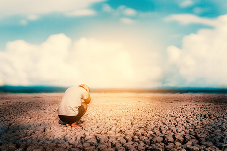 The  sad man on the crack land drought and crisis of water.の写真素材