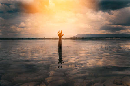 Hand and hope on the drought land and river ,save the world concept.の写真素材