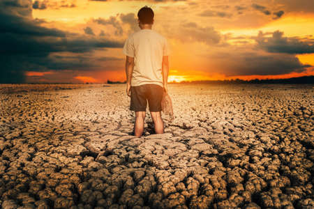 The  sad man on the crack land drought and crisis of water.の写真素材