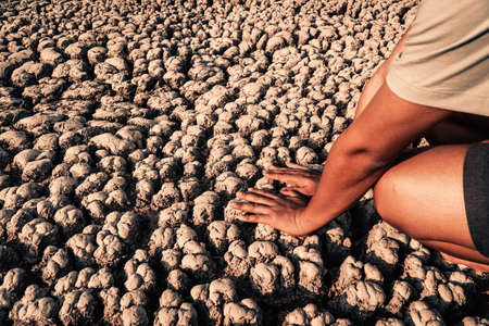Human hand checking soil on the crack land drought and crisis of water.の写真素材