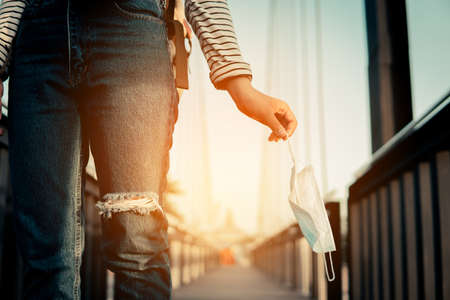 Closeup woman hand holding a mask to protect safe and health care, the new normal.